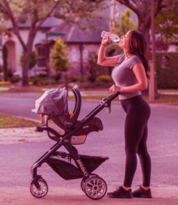 mom drinking water and a stroller