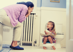 Mom sitting in the bathroom with toddler