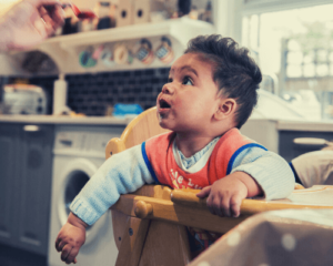 baby eating in highchair